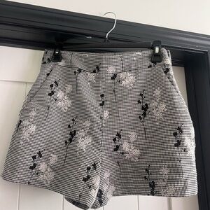 Black and white shorts with a floral design, size M